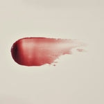 Manuka Health Eternal Renewal Nourishing Lip Balm swatch on a beige background.