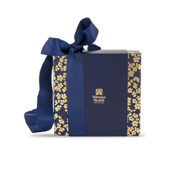 Manuka honey MGO 400+ gift set with spoon in blue gift box with gold floral patterns and a blue ribbon, featuring the Manuka Health logo.