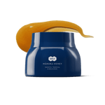 Blue jar of Manuka honey with a swatch of honey on a white background.