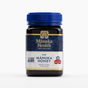 A jar of Manuka Health New Zealand MGO 263+ Raw Manuka Honey with a blue lid on a white background.